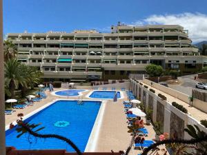 ein Hotel mit einem Pool vor einem Gebäude in der Unterkunft Luminoso apartamento con terraza y piscina in Puerto de la Cruz