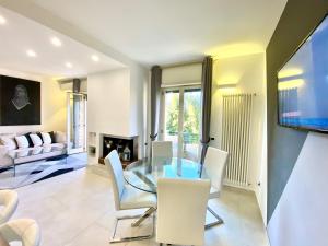 a dining room with a glass table and white chairs at Mottola Apartment in Tropea
