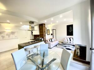 cocina y sala de estar con mesa de cristal y sillas en Mottola Apartment, en Tropea