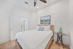 a white bedroom with a bed and a table at Seacrest Getaway in Rosemary Beach +45 photos