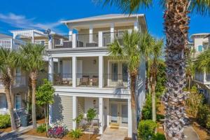 a large white house with palm trees in front of it at Seacrest Getaway in Rosemary Beach