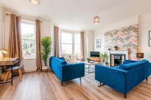 a living room with two blue couches and a fireplace at Queen Palm Apartment - Margate - 3 mins walk to beach in Margate