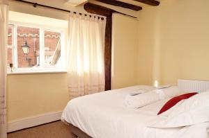 1 dormitorio con 1 cama blanca y ventana en Trade Digs High Street, en Stroud
