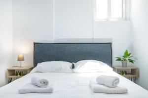 a white bed with two towels on top of it at La Pietra Verga in Kalamata
