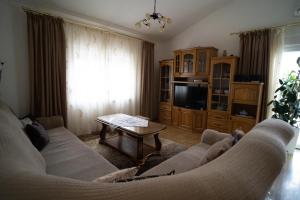 uma sala de estar com um sofá e uma mesa em Holiday Home Slap Koćuša em Ljubuški