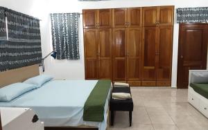 a bedroom with a bed and wooden cabinets at Villa Colonial suite n2 presidencial in Río San Juan