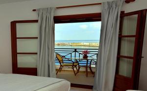 a bedroom with a balcony with a view of the ocean at Anna Maria - Vanessa Apartments in Neo Klima
