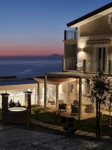 a house with a view of the ocean at night at Miramare Castellabate Resort in Santa Maria di Castellabate