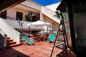 a patio with a table and chairs and an umbrella at Villa Scicchi in Castro di Lecce
