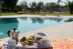 een tafel met een bord eten en twee kopjes koffie bij Villa dei Bruno in San Donato di Lecce