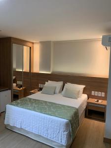 ein Schlafzimmer mit einem großen Bett mit weißen Laken und Kissen in der Unterkunft Quarto inteiro, Condomínio Vista Azul, Pedra Azul in Domingos Martins