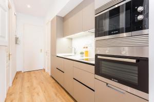 a kitchen with stainless steel appliances and a wooden floor at Cozy Apartment close to Passeig de Gracia in Barcelona