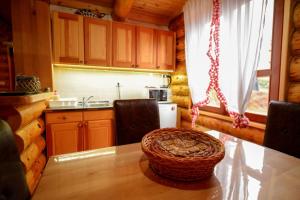 - une cuisine avec une table dans une cabane en rondins dans l'établissement Milanova koliba Zlatar, à Nova Varoš