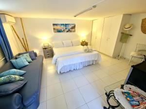 um quarto com uma cama branca e um sofá em Adonai Hotel Boutique em Willemstad