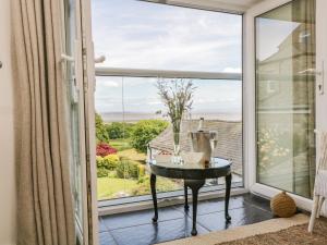een kamer met een raam met een tafel en uitzicht bij Sandacre Cottage in Ulverston