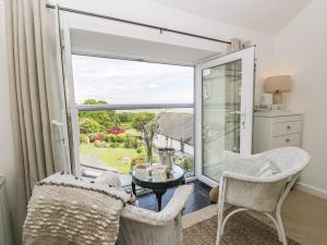 a living room with a large window and a table and chairs at Sandacre Cottage in Ulverston
