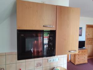 un horno microondas colgando de un armario en la cocina en Five Oaks - Rote Wohnung en Hohenkirchen