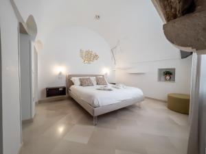 a white bedroom with a bed in a room at Domus San Giovanni in Locorotondo