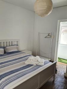 ein Schlafzimmer mit einem Bett mit einer blau-weißen gestreiften Decke in der Unterkunft Lagos Haven Guesthouse in Lagos
