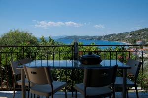 einen Tisch und Stühle auf einem Balkon mit Blick auf das Wasser in der Unterkunft Villa Anna in Megali Ammos