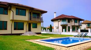 una casa con piscina frente a una casa en Вила Роза - Villa Rosa, en Balgarevo