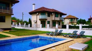 a house with a swimming pool in front of a house at Вила Роза - Villa Rosa in Bŭlgarevo
