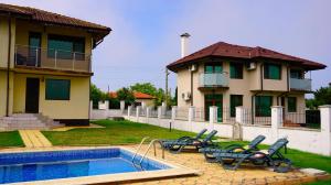 una casa con piscina y sillas junto a una casa en Вила Роза - Villa Rosa, en Balgarevo