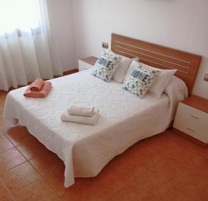 1 dormitorio con 1 cama grande y 2 toallas. en Casa Yaya Felisa, en Lledó