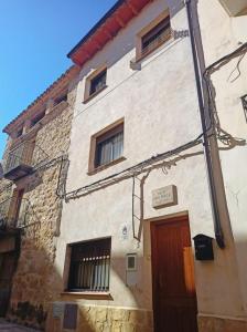 a large stone building with a red door at Casa Yaya Felisa in Lledó