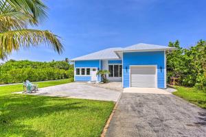 a blue house with a palm tree in front of it at Hutchinson Island Cottage Steps to the Beach in Fort Pierce
