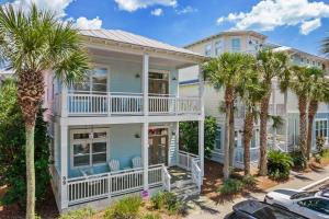 a house with palm trees in front of it at Aquanut Beach House 30A in Inlet Beach