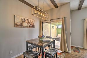 坦培3 Mi to Mill Ave Central Condo with Patio in Tempe的配有木桌椅的餐厅