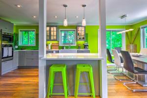 una cucina con pareti verdi e bancone con sgabelli di Game Room and Mountain Views Lake Lure Retreat! a Lake Lure