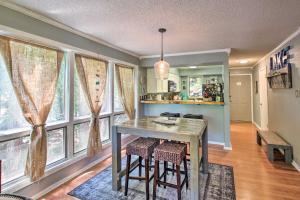 a dining room with a table and some windows at Mount Ida Condo with Balcony and Resort Amenities in Mount Ida