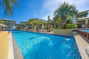 a pool at a resort with palm trees and buildings at Aquanut Beach House 30A in Inlet Beach