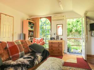 a living room with a couch and a window at Detox Dunchideock in Exeter