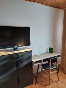 einen Schreibtisch mit einem TV und einem Stuhl in einem Zimmer in der Unterkunft Olive Tree in Zadar