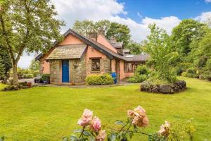 une maison dans une cour avec une pelouse verte dans l'établissement Catstone Lodge, 