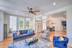 sala de estar con sofá azul y ventilador de techo en Chic Home with Patios, Steps to Oceanside Beach, en Oceanside