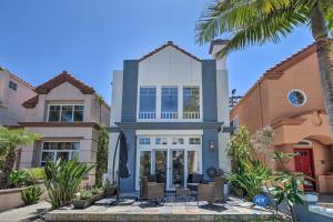 a house with a palm tree in front of it at Oceanside Home with Rooftop Patio - Steps to Beach! in Oceanside