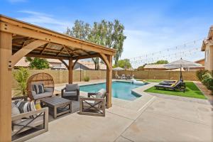 a backyard with a swimming pool and a pavilion at Beautiful Chandler Escape with Putting Green and Pool! in Chandler