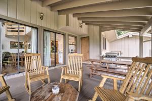 a porch with wooden chairs and a wooden table at Mountain Views and Deck Spacious Bryson City Home! in Bryson City