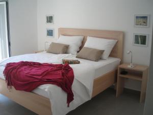 - une chambre avec un lit et une couverture rouge dans l'établissement Haus Helga, à Rab