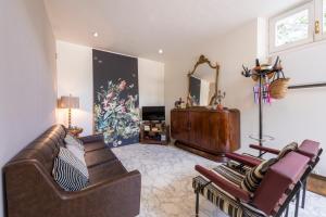 a living room with two leather couches and a mirror at Piave Suites by Mmega in Forte dei Marmi