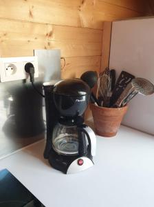 eine schwarz-weiße Kaffeemaschine auf der Theke in der Unterkunft WhispeRive Lodge - le vert aux bords de rive in Le Bourg-dʼOisans