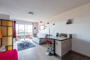 een keuken en een woonkamer met een tafel en een bank bij Grand Studio Avec Piscine Presqu'île De Giens in Hyères