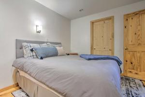a bedroom with a bed and a wooden door at Modern Mountain-View Condo at Big Sky Resort! in Big Sky