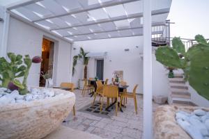 a patio with a table and chairs and plants at Corte Fantasia in Triggianello