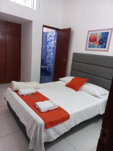 1 dormitorio con 1 cama grande con almohadas rojas y blancas en Hostal Resident, en Piura