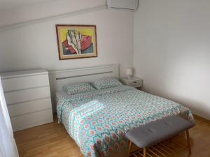 a bedroom with a bed and a picture on the wall at Apartments Lav in Umag